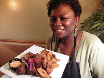 Bernadette Jean-Francois shows off Griot, Haiti’s dish of fried pork chunks with pikliz slaw.