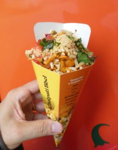  Bhel snack mix features puffed rice and other crispy bits, topped with tomato, chopped onion and cilantro.